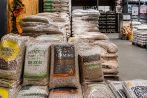 Sacs de pellets 15 kg empilés en magasin Leclerc avec palette en arrière-plan
